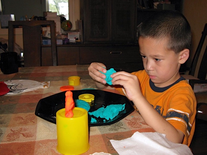Image of child moulding clay by Dave Null released via Creative Commons CC BY-NC 2.0