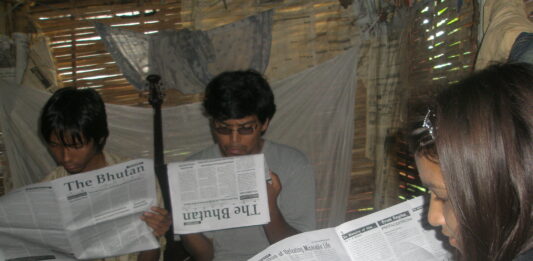 Bhutanese refugees reading a copy of The Bhutan Reporter in the Beldangi-II refugee camp. Photo by TP Mishra.
