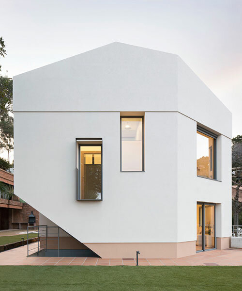 sculptural residence in spain emerges as an all-white monolith among tall pines